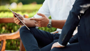 A photo of a man's hands pointing to an iPad