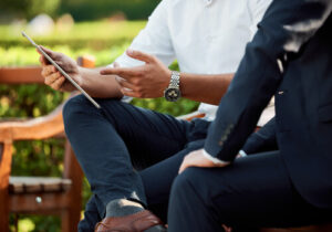A photo of a man's hands pointing to an iPad
