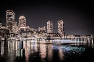 A photo of the Boston skyline taken at night from Boston Harbor